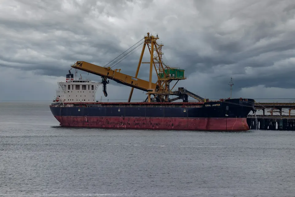 Dry bulk vessel alongside terminal cargo handling equipment